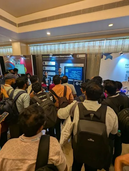 A crowd of attendees gathered around the Randoli booth at KCD Bengaluru 2025, where a team member presents in front of a 'Rethink Kubernetes Observability' display