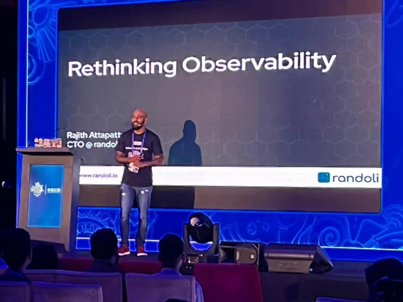 Rajith Attapattu, CTO at Randoli, presenting on stage at KCD Sri Lanka 2025 in front of a slide titled 'Rethinking Observability'